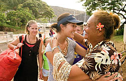 Lanai Lady welcoming Trilogy guests with shell leis in hand